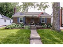 Charming brick home with a cozy porch and well-manicured lawn at 5829 Indianola Ave, Indianapolis, IN 46220