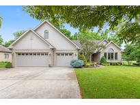Charming brick home with a well-manicured lawn, mature trees, and a spacious three-car garage at 6980 White Oak Dr, Avon, IN 46123