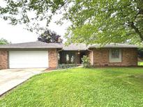 Charming brick home with attached garage and well-maintained lawn at 7721 Hollybrook Ln, Indianapolis, IN 46227