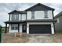 Two-story home featuring a black two car garage and light siding with black trim and grey roof at 9137 Steinbeck Ln, Indianapolis, IN 46239