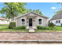 Charming single-story home featuring neutral siding and a quaint entrance with a brick path and manicured landscaping at 917 W Pearl St, Lebanon, IN 46052