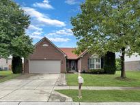 Charming brick home featuring a well-manicured lawn and a two-car garage at 9302 N Bayland Dr, McCordsville, IN 46055