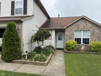 Charming home entrance with brick accents, green shrubs, garden bed and well-maintained lawn at 982 Ramsgate Rd, Greenwood, IN 46143