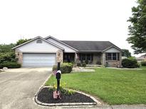 Charming single-story brick home featuring a well-manicured lawn and attached two-car garage at 1027 Springway Dr, Shelbyville, IN 46176