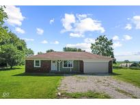 Charming single-story home featuring a brick accent, covered entry, and an attached garage on a sunny, tree-lined lot at 10727 N Shupe Rd, Monrovia, IN 46157