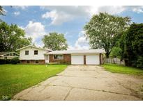 Charming two-story home with a spacious two-car garage and a well-maintained front lawn under a blue sky at 1217 S Post Rd, Indianapolis, IN 46239