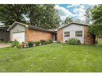 Charming brick home with a well-manicured lawn and flower beds at 13 Fairlane Dr, Brownsburg, IN 46112
