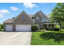 Charming two-story brick home with a three-car garage and manicured front lawn at 13355 Freenza Ct, Carmel, IN 46074