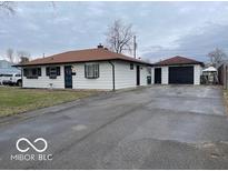Charming single-story home with detached garage and long driveway on a cloudy day at 1610 Douglas Ln, Lebanon, IN 46052