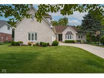 Charming brick home featuring a well-manicured lawn, curved driveway, and lush landscaping at 18432 Oriental Oak Ct, Noblesville, IN 46062
