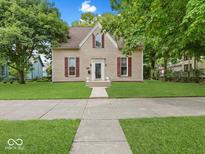 Charming two-story home with red shutters, pristine lawn, and inviting walkway to the front door at 228 W Washington St, Shelbyville, IN 46176