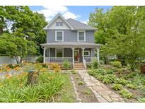 Charming two-story home featuring a welcoming front porch and professionally landscaped front yard with stone pathway at 23 S Downey Ave, Indianapolis, IN 46219