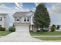 Charming two-story home featuring neutral siding, an attached garage, and a well-manicured front lawn at 2615 Pumpkin Patch Ln, Indianapolis, IN 46229