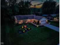 Charming single-story home featuring a brick facade, manicured lawn, and attached garage at 272 N Peterman Rd, Greenwood, IN 46142