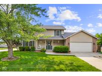 Charming two-story home with a well-manicured lawn, inviting porch, and attached two-car garage at 2872 N Prairie Stream Way, Columbus, IN 47203