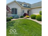 Charming single-story home featuring a well-manicured lawn, mature landscaping, and light brick exterior at 3354 Nottinghill Dr, Plainfield, IN 46168