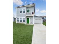 Charming two-story home with light gray siding, green door, and an attached garage on a lush lawn at 3813 N Lawndale Ave, Indianapolis, IN 46254