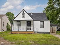 Charming home with a covered front porch, black and white trim and a well-manicured lawn at 3822 Haverhill Dr, Anderson, IN 46013