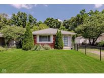 Charming single-story home with a well-manicured lawn, mature trees, and brick accents at 4218 E 18Th St, Indianapolis, IN 46218