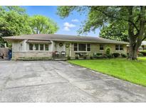 Charming single-story home with a well-maintained lawn and inviting front porch seating at 7113 Chandler Dr, Indianapolis, IN 46217