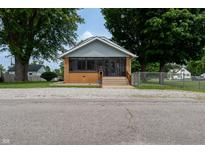 Charming home with a screened-in porch and well-maintained front yard at 7727 Huff St, Indianapolis, IN 46259