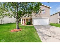 Charming home featuring a well-manicured lawn, lovely landscaping, and an attached two-car garage at 8310 Becks Mill Ln, Indianapolis, IN 46113