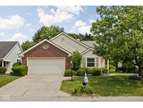 Charming single-Gathering home with brick accents, attached garage and mature landscaping at 8753 Champions Dr, Indianapolis, IN 46256