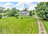 Charming home with a large front lawn, mature trees, and a gravel driveway offers great curb appeal at 1130 E 105Th St, Carmel, IN 46280