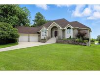 Charming brick home featuring a well-manicured lawn and a two-car garage with beautiful shrubbery at 1326 Pebble Brook Dr, Noblesville, IN 46062
