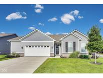 Charming single-story home with a manicured lawn, attached garage, and inviting front entrance at 1396 Lexington Trl, Greenfield, IN 46140