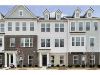 Modern townhome featuring a brick and white facade with large windows and a welcoming entrance at 14521 Hanford Ln, Carmel, IN 46074