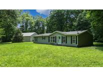 Charming single-story home with green lawn, surrounded by lush trees and front yard at 290 S Buffalo Hill Rd, Martinsville, IN 46151