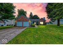 Charming single-story brick home featuring an attached two-car garage and a lush green front yard at 3025 Sable Ridge Ln, Greenwood, IN 46142