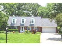 Charming brick home with dormer windows, lush lawn, and mature trees at 3115 E 400 S, Anderson, IN 46017