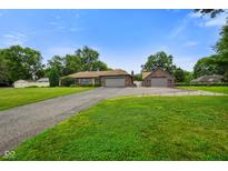 A charming ranch home featuring an attached and detached garage with a sprawling green lawn at 3707 E Wilson Dr, Mooresville, IN 46158