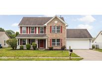 Charming brick two-story home with a well-manicured lawn and lovely red shutters at 6955 Long Run Dr, Indianapolis, IN 46268