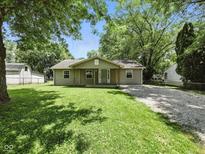 Charming single-story home with a well-maintained lawn, mature trees, and a gravel driveway at 7434 N Green Meadows, Fairland, IN 46126