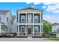 Charming two-story home with large front porch, white columns, fenced in yard and blue siding at 776 Templeton Dr, Carmel, IN 46032