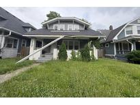 Gray two-story home with a black shingle roof and front yard at 917 N Rural St, Indianapolis, IN 46201