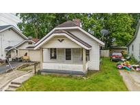 Charming home featuring a covered front porch, brick chimney, and a compact yard needing some attention at 1011 W 7Th St, Anderson, IN 46016