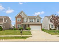 Charming two-story home featuring brick and vinyl siding, a well-manicured lawn, and an attached two-car garage at 10334 Deercrest Ln, Indianapolis, IN 46239