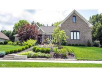 Beautiful brick home featuring meticulously landscaped front yard and well-maintained lawn at 10707 Burning Ridge Ln, Fishers, IN 46037