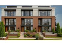 Beautiful brick townhomes with large windows and landscaped front yards provide a modern and inviting street view at 11972 Citywalk Dr, Fishers, IN 46038