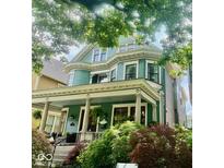 Beautiful two-story home featuring a welcoming porch and lush landscaping at 2050 N Alabama St, Indianapolis, IN 46202