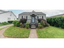 Charming home featuring a welcoming front porch, well-maintained lawn, and lush landscaping at 2249 Maple St, Columbus, IN 47201