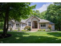 Charming brick home with manicured lawn, blooming flowers, and a covered front porch entrance at 23119 Sonoma Ln, Cicero, IN 46034