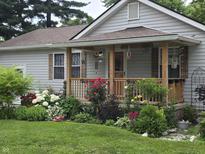 Charming home featuring a cozy covered porch, beautiful landscaping, and welcoming curb appeal at 2412 Mars Hill St, Indianapolis, IN 46241