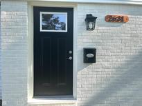 Charming front door with black paint, white brick and modern light fixture at 2631 Mcleay Dr, Indianapolis, IN 46220