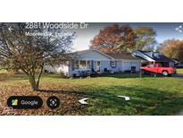 Charming single-story home with attached garage and well-maintained lawn in a suburban setting at 2875 E Woodside Dr, Mooresville, IN 46158