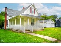Charming home featuring a welcoming front porch, well-maintained lawn, and detached garage at 410 Plum St, Frankton, IN 46044